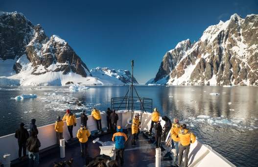 Passengers stand at the bow of the ship, as they cruise the Lemaire Channel. Photo: Acacia Johnson Photo by Acacia Johnson