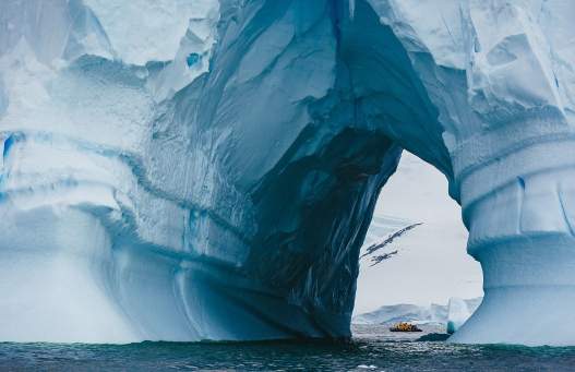 A zodiac spotted through an iceberg, in the Antarctic Peninsula. Photo: David Merron